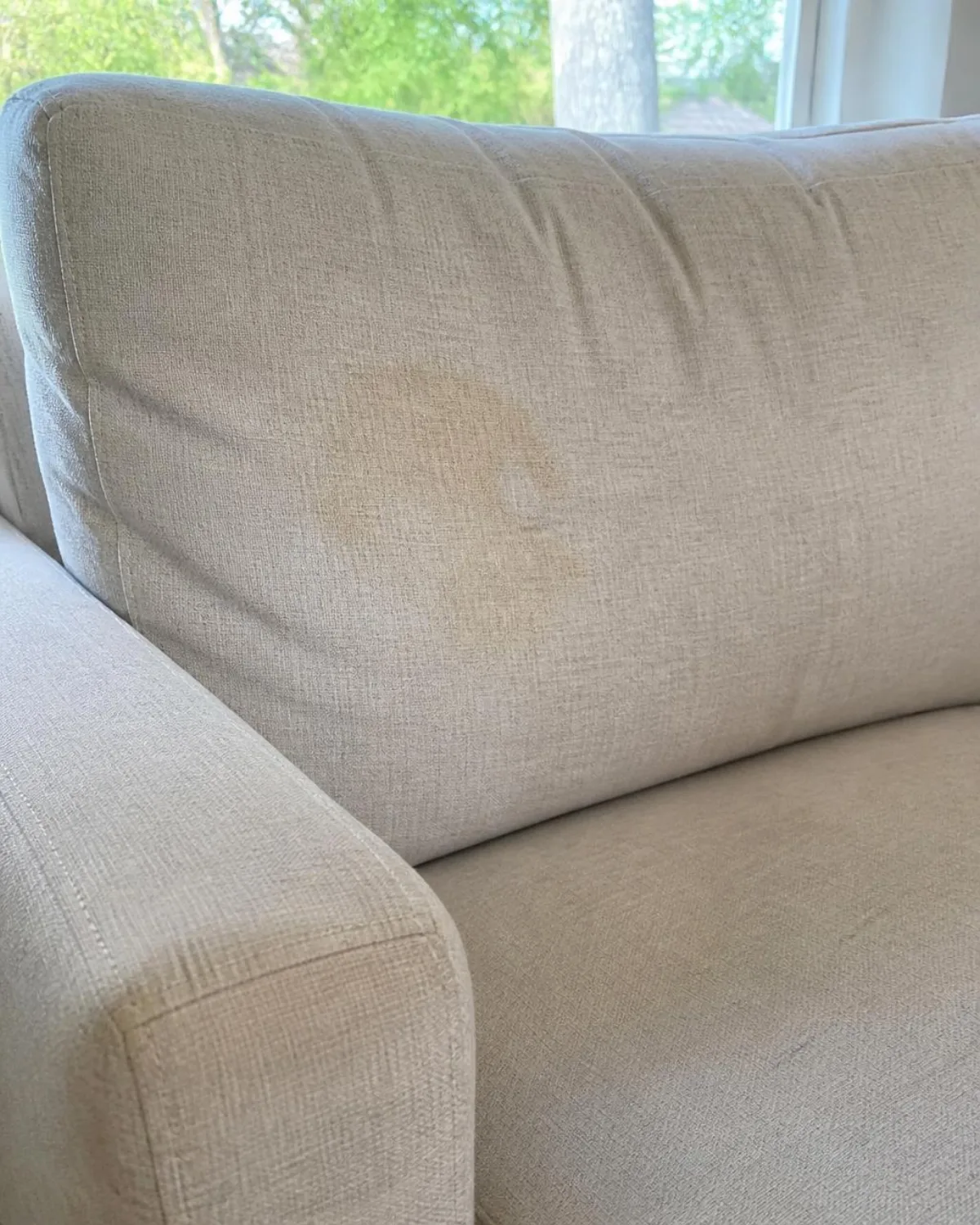 Cream sofa cushion before treatment, with a stain